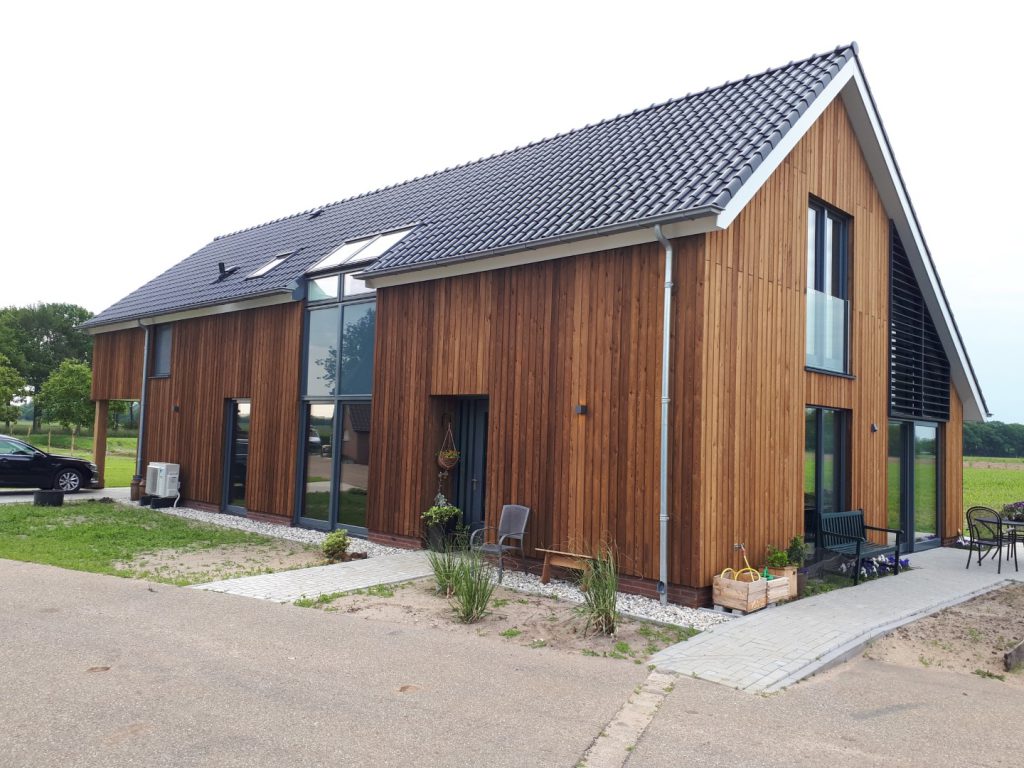 Nieuwbouwwoning met houten gevel en eikenhouten constructie op een voormalig boerenerf in Schalkhaar