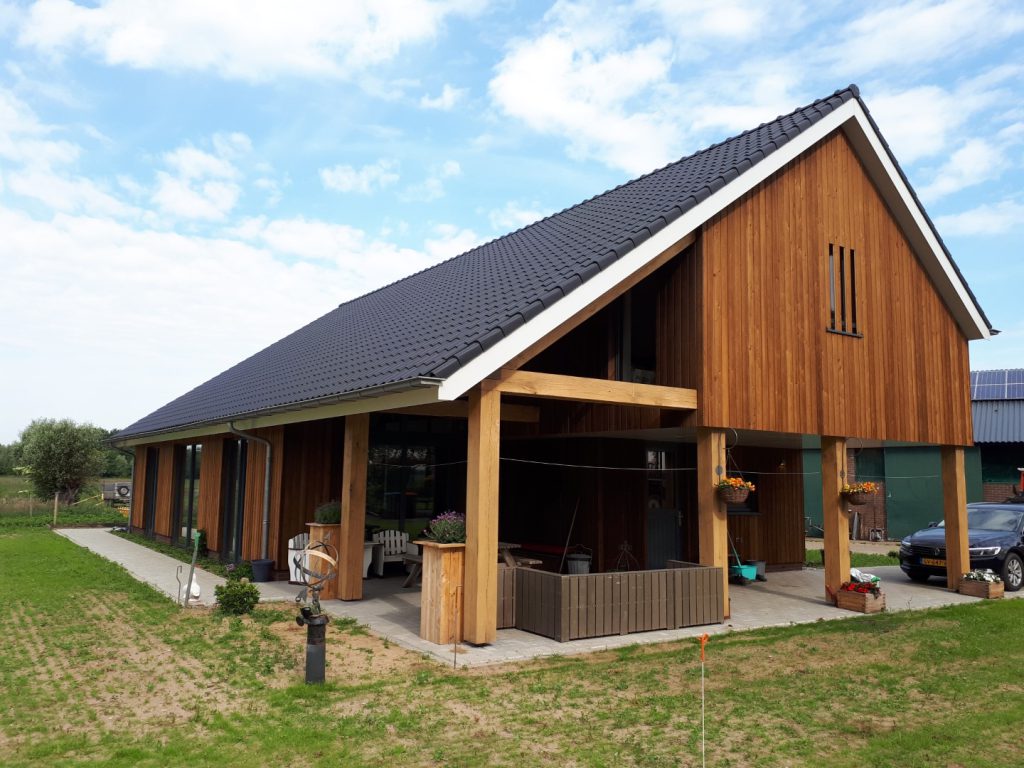 Nieuwbouwwoning met houten gevel en eikenhouten constructie op een voormalig boerenerf in Schalkhaar
