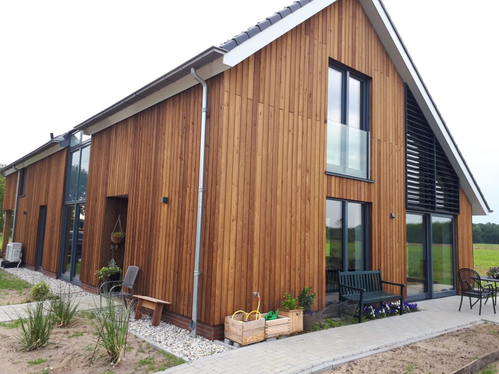 Nieuwbouwwoning met houten gevel en eikenhouten constructie op een voormalig boerenerf in Schalkhaar