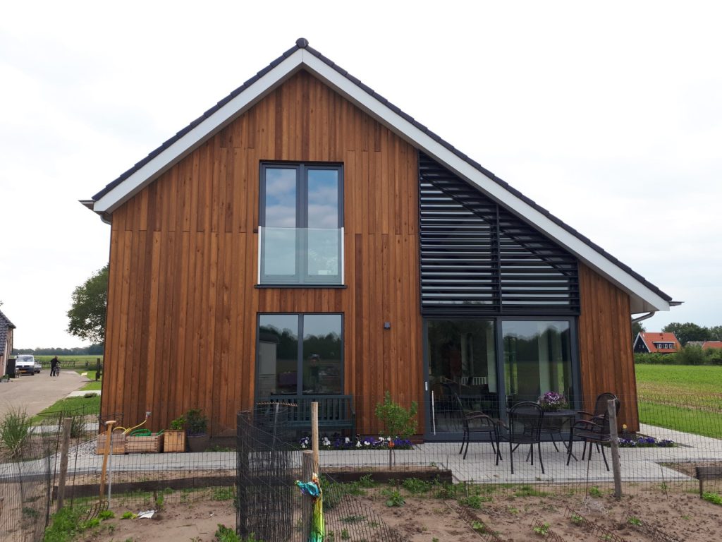 Nieuwbouwwoning met houten gevel en eikenhouten constructie op een voormalig boerenerf in Schalkhaar