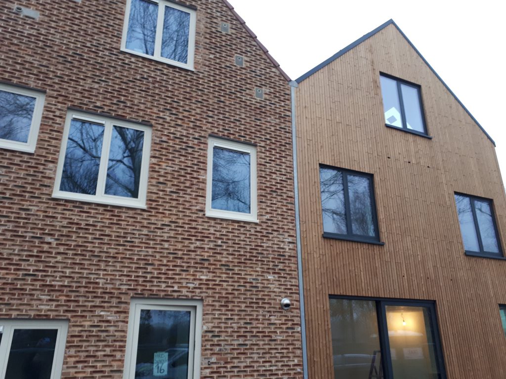 Aansluiting van houten gevelbekleding op metselwerk bij geschakelde woningen in Deventer