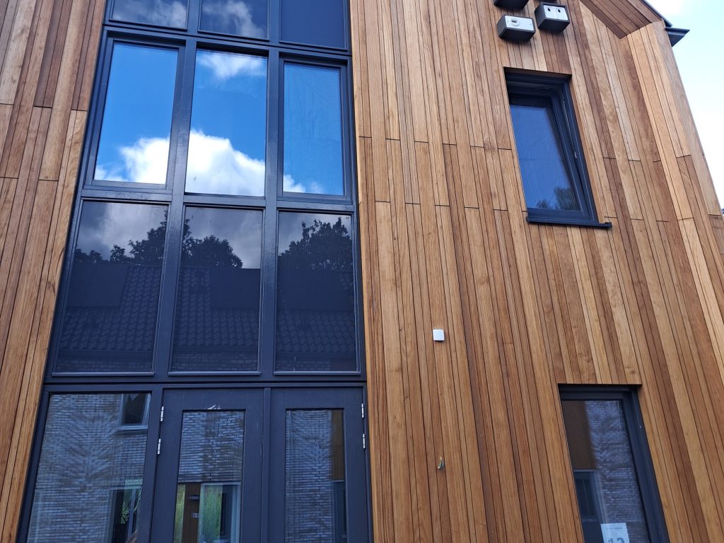 Detail van houten gevelbekleding rond de kozijnen van een nieuwbouwwoning in Deventer