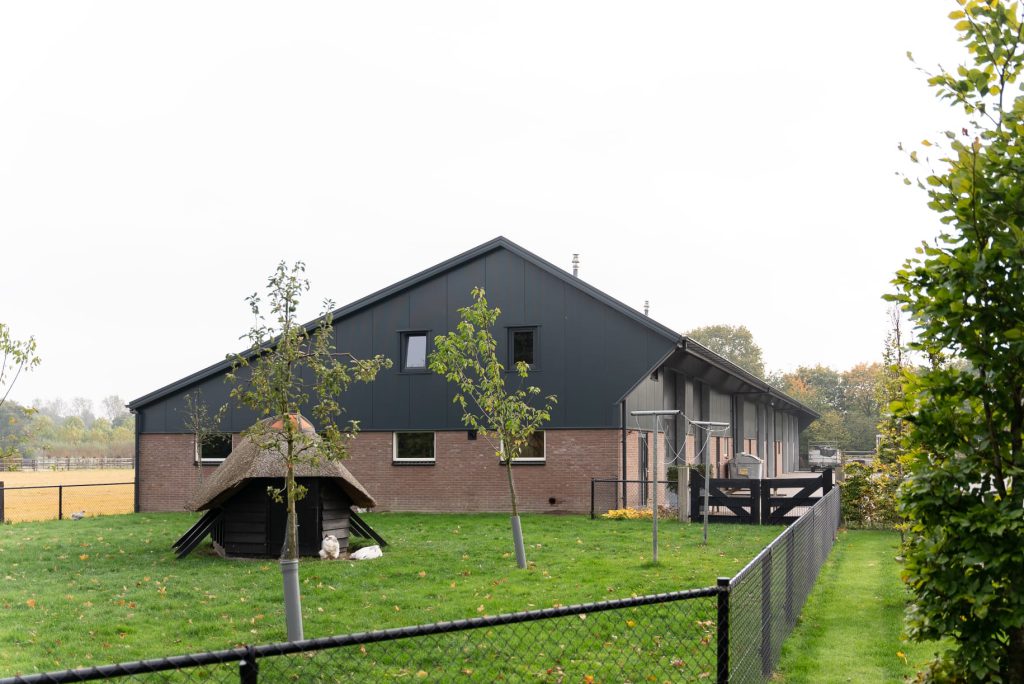 Opslagloods met donkere FALK-panelen en gemetselde plint in Putten