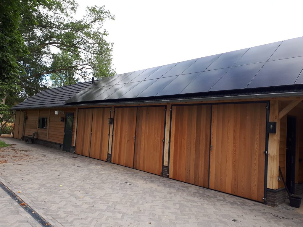 Paardenstal met houten gevel en zonnepanelen in Joppe